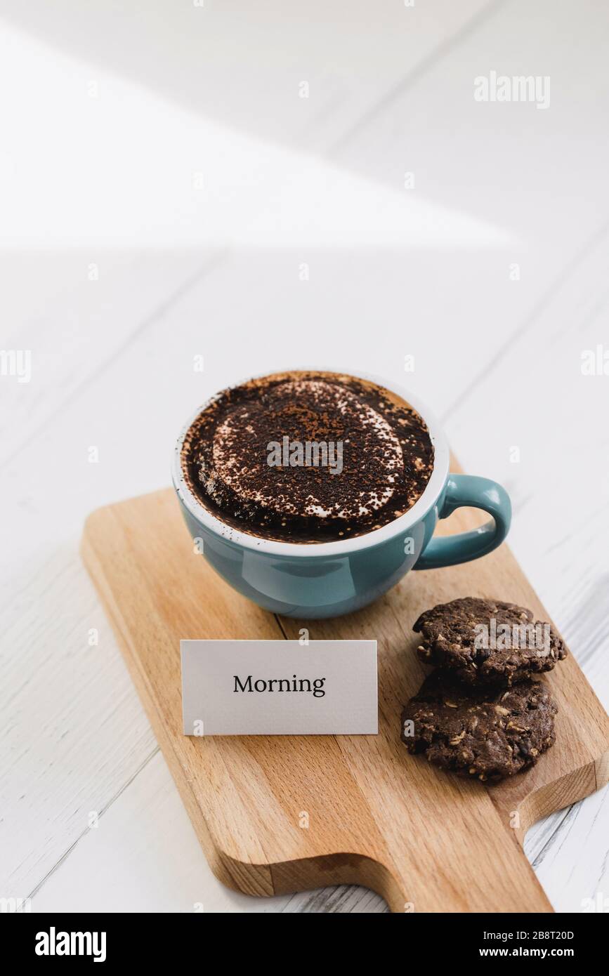 Tasse de café avec biscuits au chocolat noir et message de bienvenue sur un plateau de bois dans le café Banque D'Images
