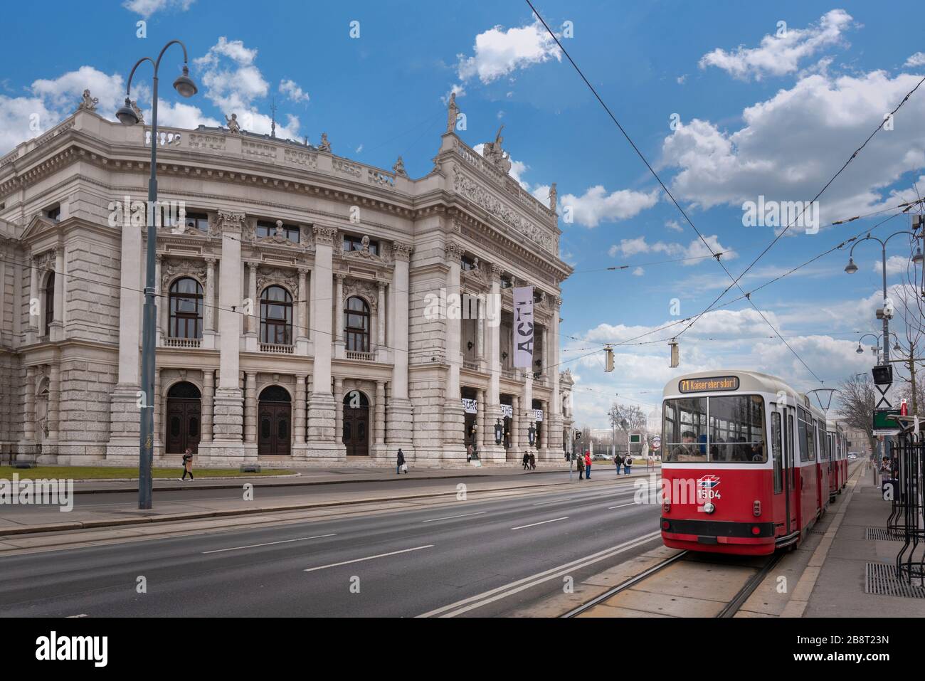 Vienne, Autriche. Célèbre Wiener Ringstrasse avec le Burgtheater historique (Théâtre de la Cour impériale) et le tramway électrique rouge traditionnel au lever du soleil Banque D'Images