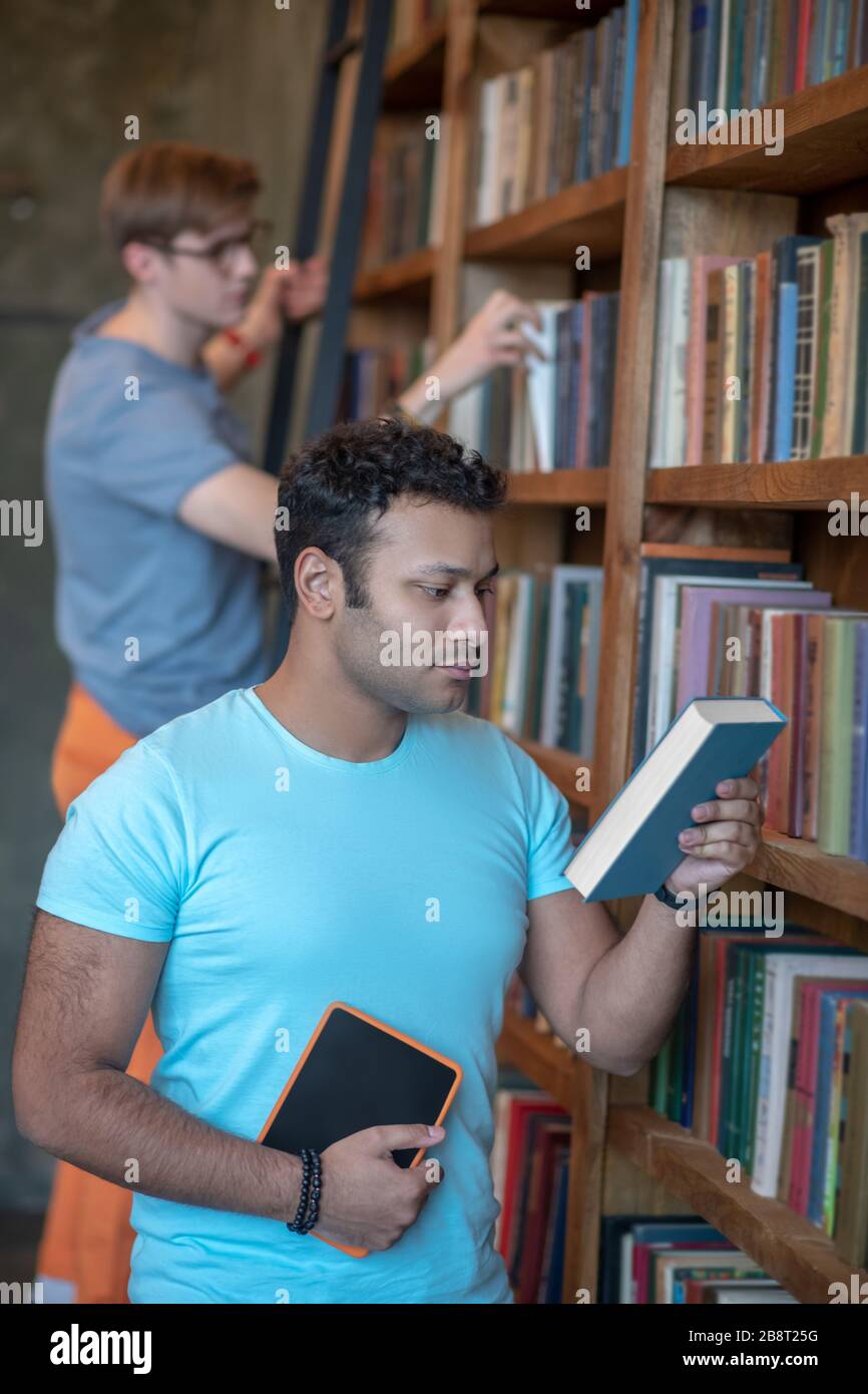 Deux amis à la recherche des livres nécessaires pour la préparation aux examens Banque D'Images