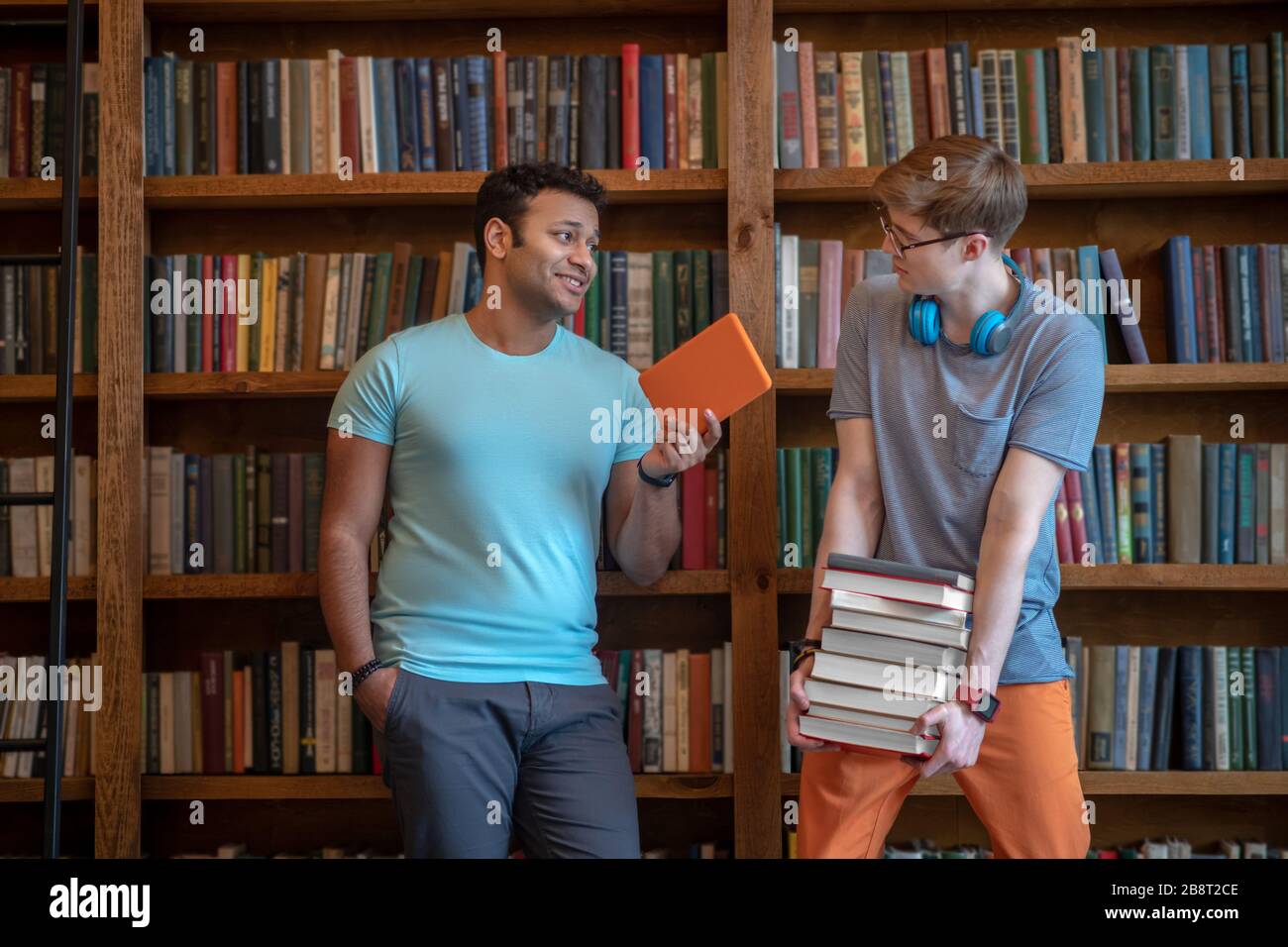 Deux jeunes hommes passent la journée ensemble dans la bibliothèque Banque D'Images
