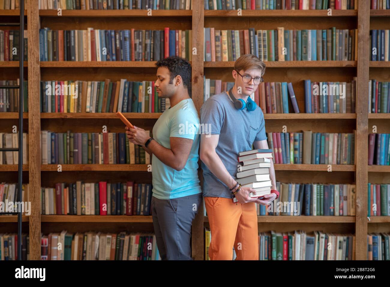 Deux jeunes hommes se tenant dans la bibliothèque de retour à l'arrière Banque D'Images