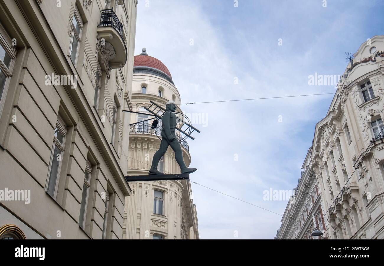 Vienne, Autriche. Statue d'un ouvrier de cheminée avec une échelle accrochée sur un bâtiment historique à Vienne. Banque D'Images