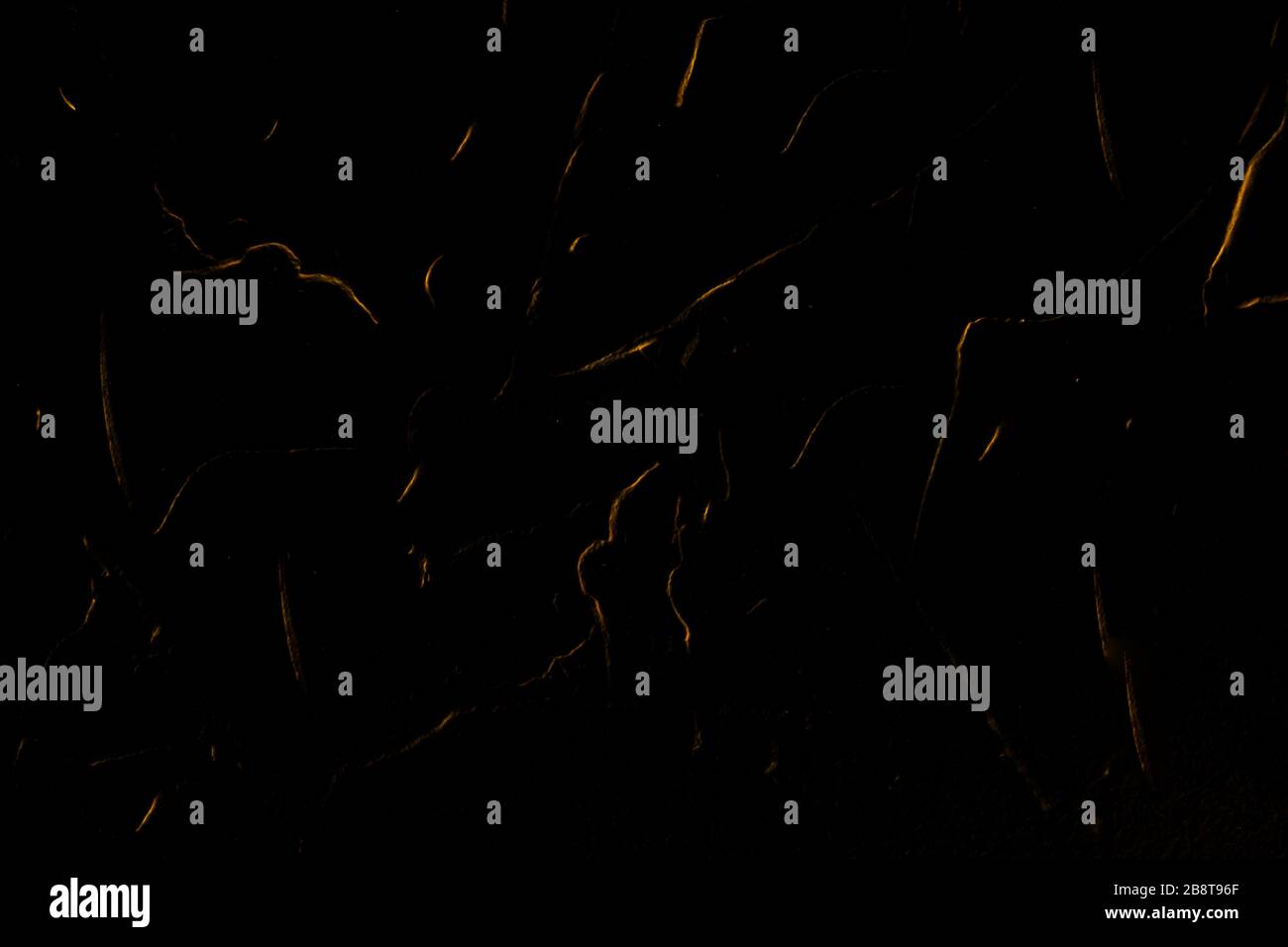 Fond noir mat texturé de couleur noire profonde. Un arrière-plan décoratif abstrait étonnant avec des traînées, des lignes et des traits dorés. Banque D'Images