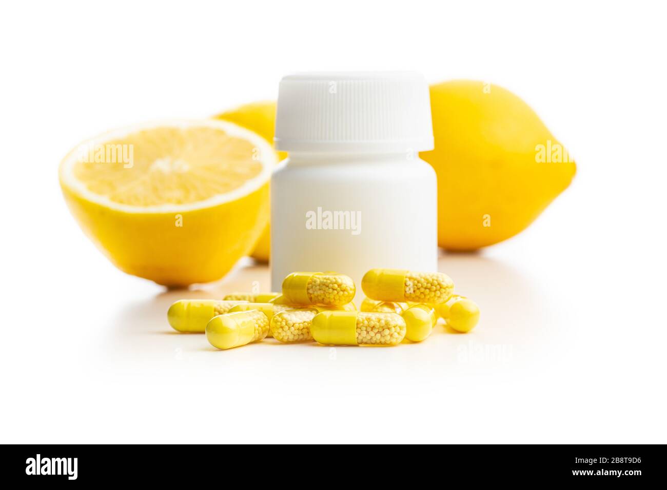 Capsules de vitamines. Pilules de vitamine C avec flacon de pilule et fruits de citron isolés sur fond blanc. Banque D'Images