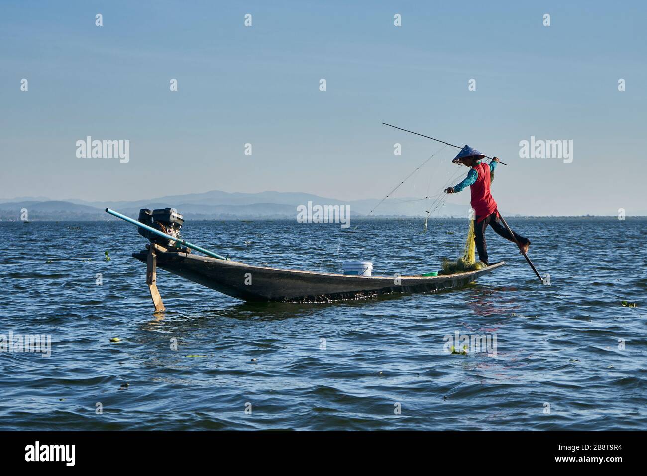 Fischer mit Netz in Ihrem Boot am Flussufer, Insel Jinack Island