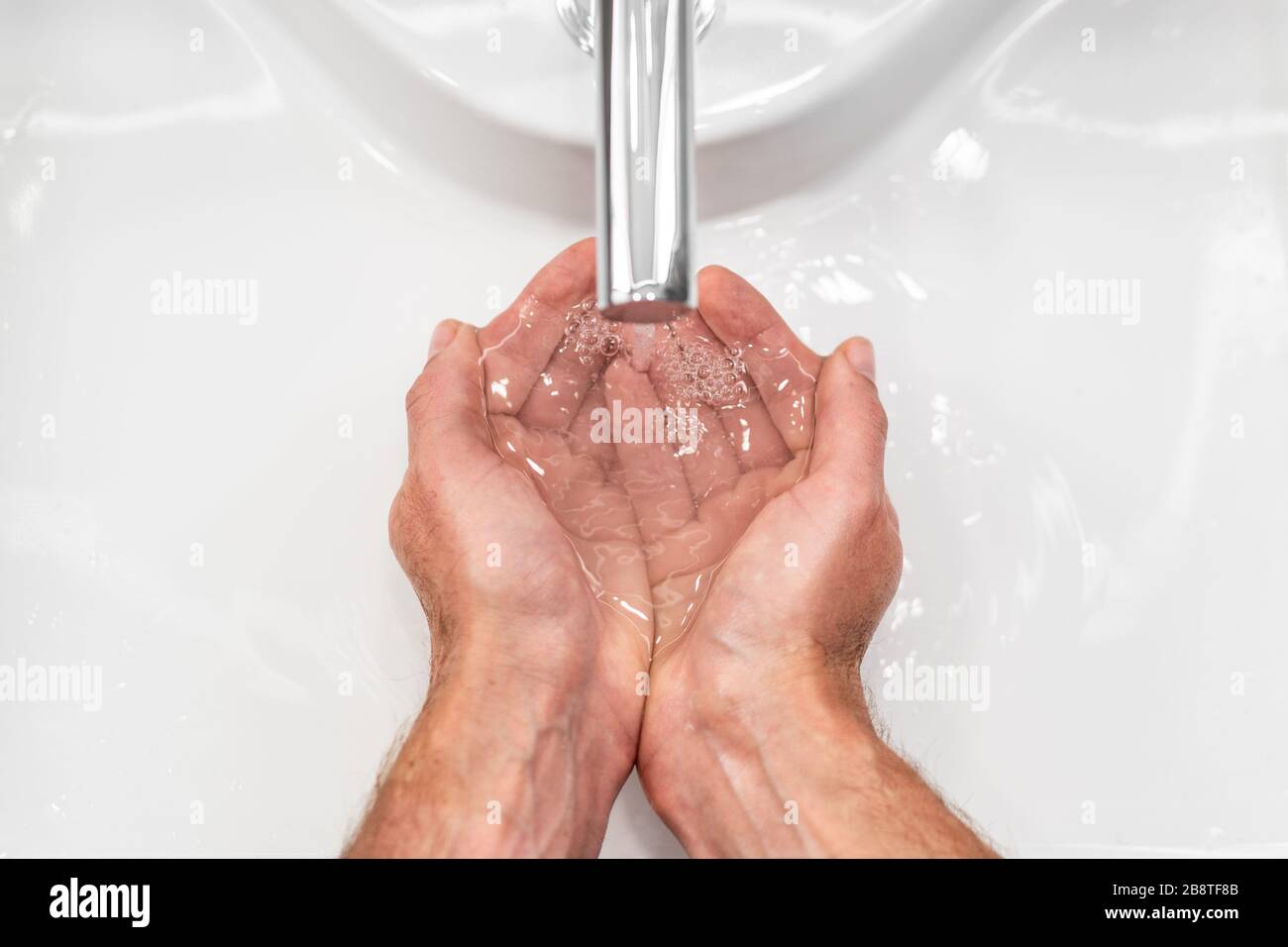 Se laver les mains avec du savon hygiène des mains pour prévenir la propagation du coronavirus corona virus. Vue de dessus des mains masculines frottant sous l'eau Banque D'Images