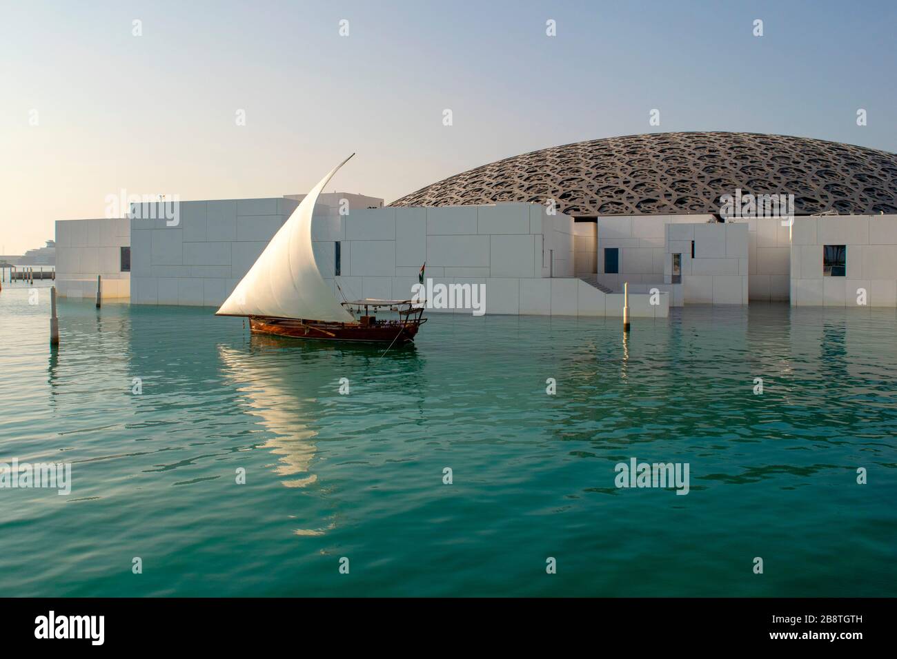 Émirats Arabes Unis / Abu Dhabi - 3 janvier, 2019 : musée du Louvre à Abu Dhabi. Belle vue du Louvre extérieur avec bord de l'eau et voilier en bois. Banque D'Images