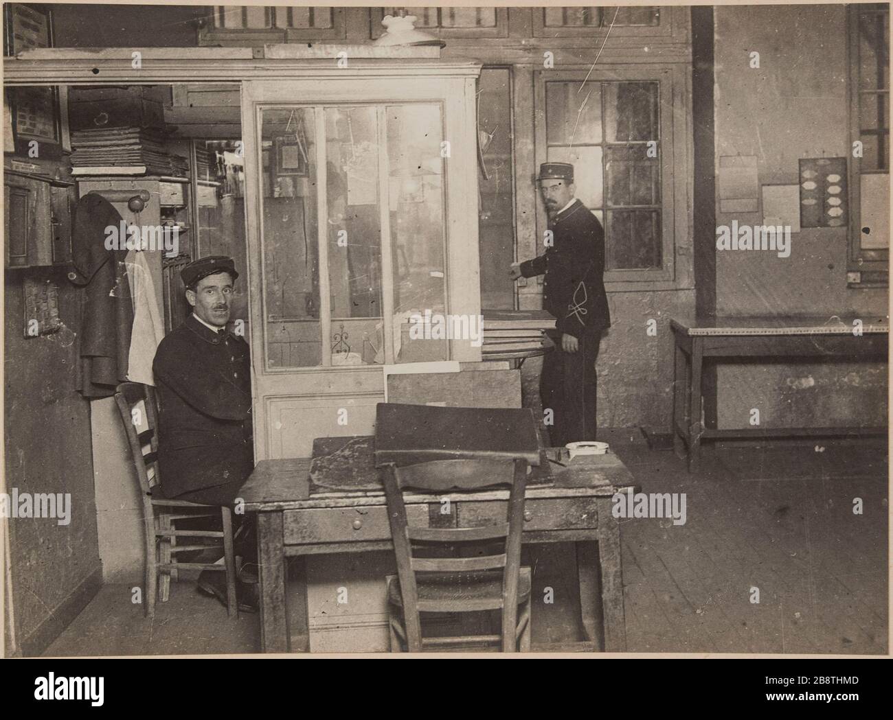 Vue de l'entrée principale avec deux gardes officiels de l'administration pénitentiaire en uniforme à l'entrée de la greffe. Prison Saint-Lazare, prison pour femmes, 107 rue du Faubourg Saint-Denis, 10ème arrondissement, Paris. Vue de l'entrée principale avec les gestionnaires de l'administration scolaire en uniforme à l'entrée du greffe. Prison Saint-Lazare, maison d'arrêt pour femmes, 107 rue du Faubourg-Saint-Denis. Paris (Xème arr.). Photographie d'Henri Manuel (1874-1947). Rage gélatino-argentique au bromure sur papier, collage sur une page d'album cartonnée. Agrandisation d’après une Banque D'Images