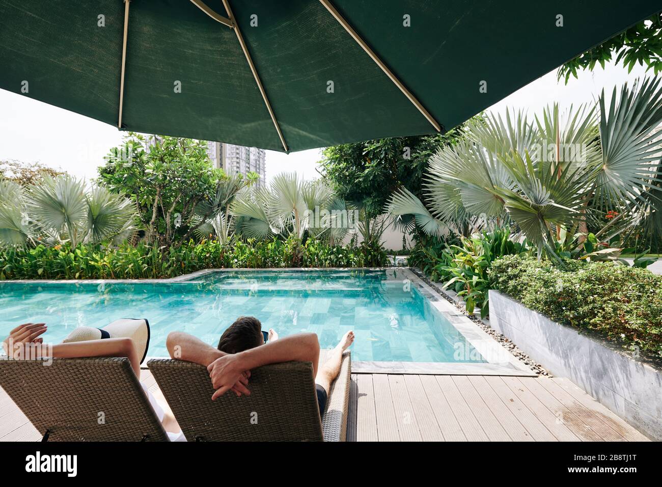 Les jeunes couples qui apprécient de passer du temps en profitant de la piscine isolée du petit hôtel de spa de la grande ville Banque D'Images