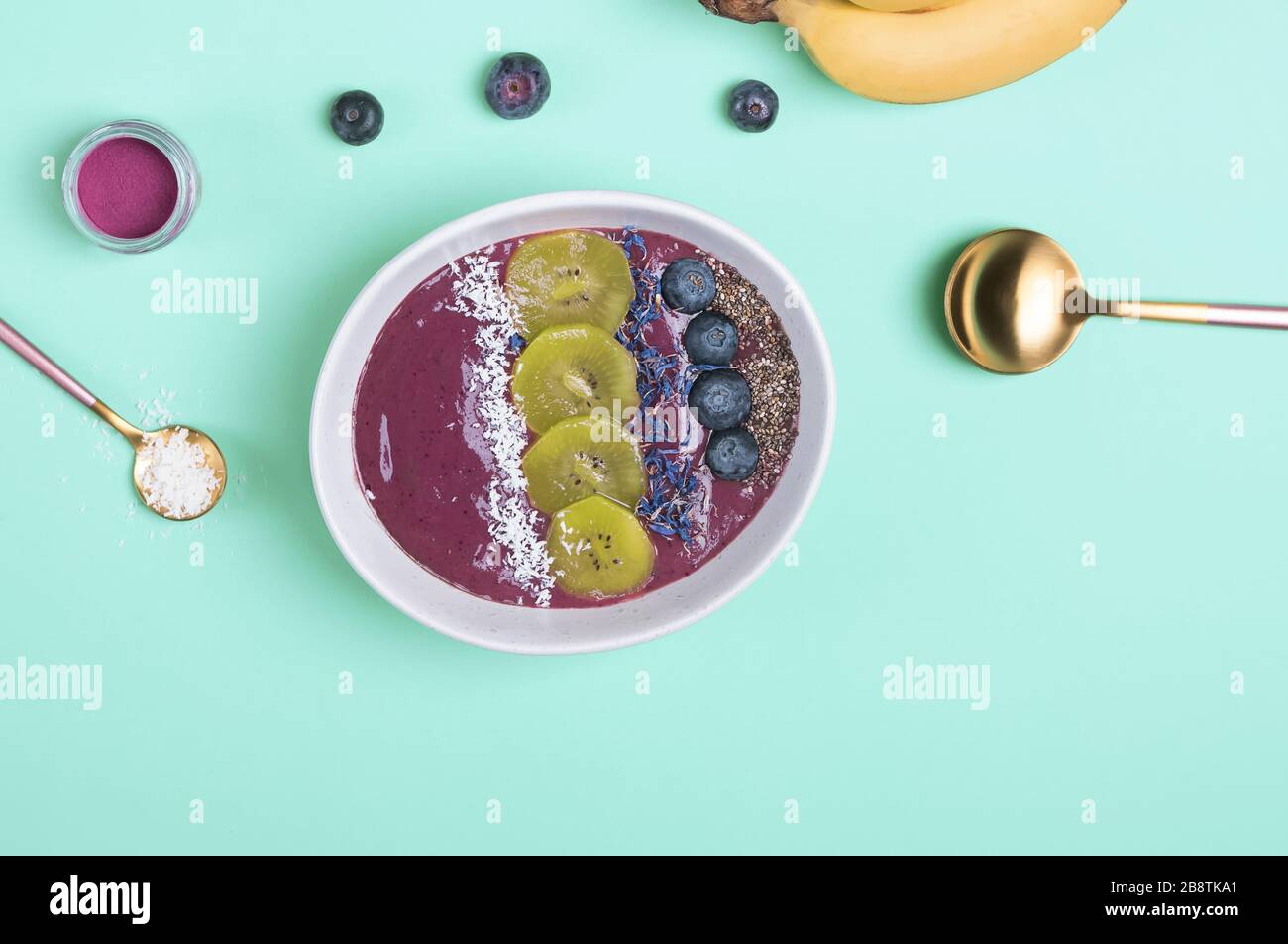 Bol à smoothie aux baies d'acai garni de graines, de fleurs et de mûres Banque D'Images