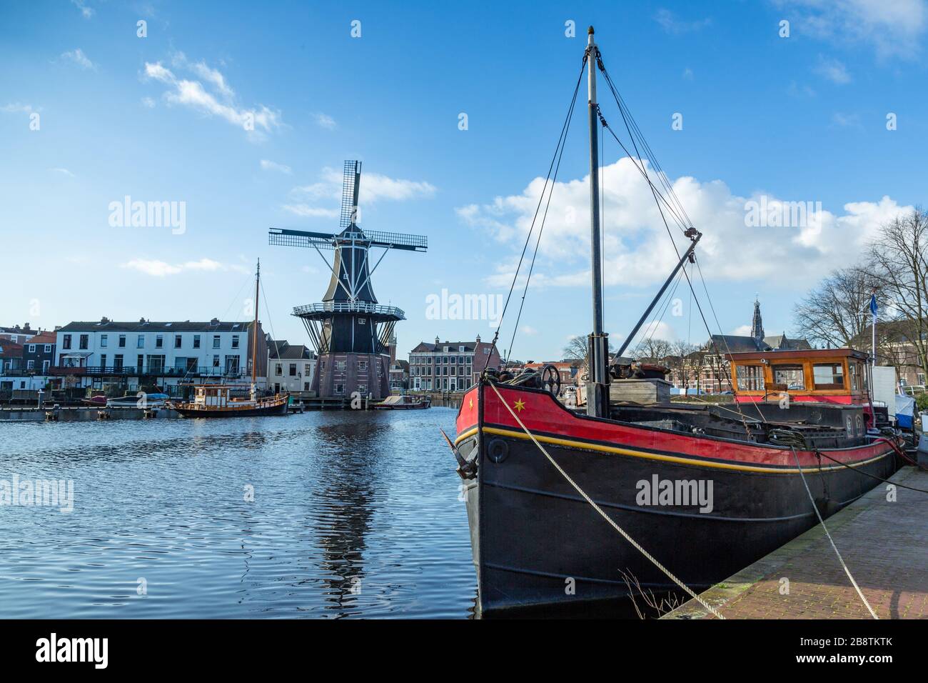 Pays-Bas: Barge de la rivière Haarlem avec moulin à vent de Adriaan en arrière-plan. Le moulin à vent d'origine date de 1779. Banque D'Images