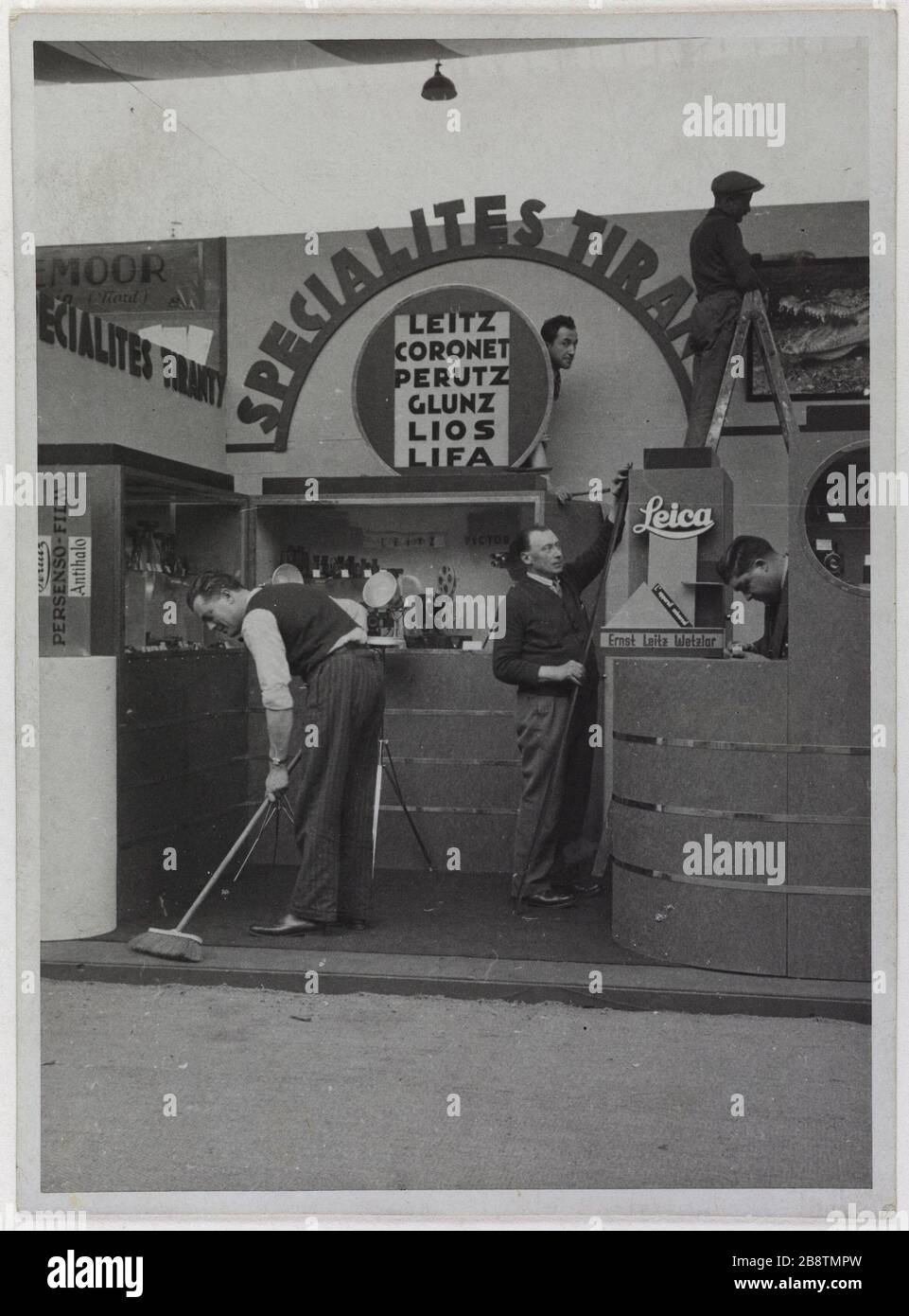 Stand Tyranty spécialités avec la caméra Leica, le magasin Printemps, Boulevard Haussmann, 9ème arrondissement, Paris. Tyranty spécialités Stand de Spécialtés Tyranty avec l'appareil Leica, magasin 'le Printemps', boulevard Haussmann. Paris (IXème arr.). 'Spécialités Tyranty'. Photographie anonyme. Rage au gélatino-bromure d’argent. Paris, musée Carnavalet. Banque D'Images