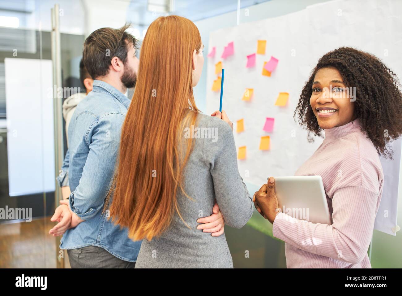 Jeune femme d'affaires africaine avec équipe créative dans un atelier de brainstorming créatif Banque D'Images
