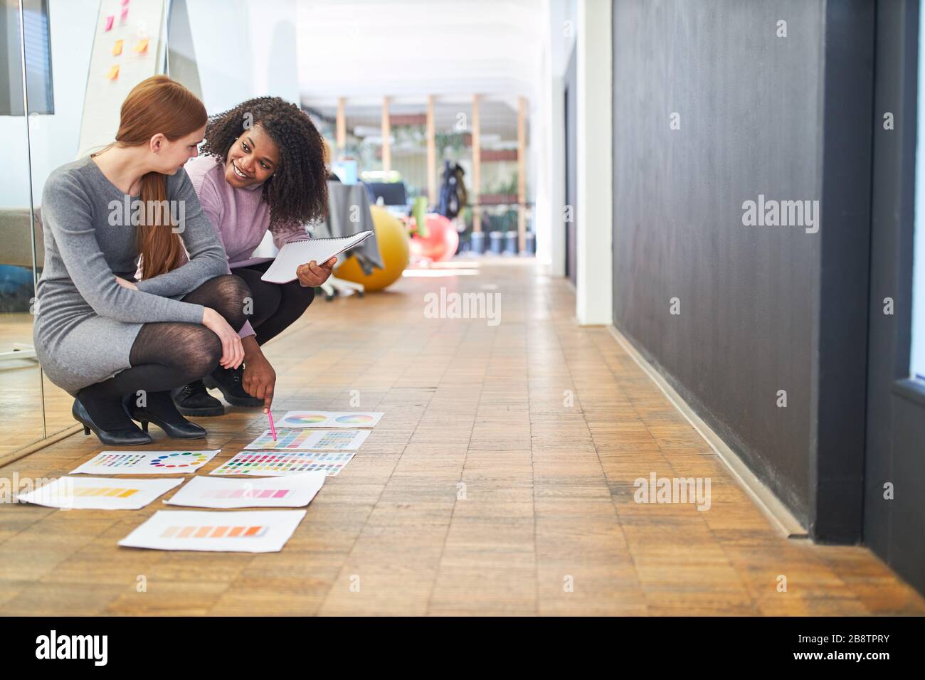 Deux jeunes femmes en tant que graphistes contrôlent le prépresse pour la conception des couleurs Banque D'Images