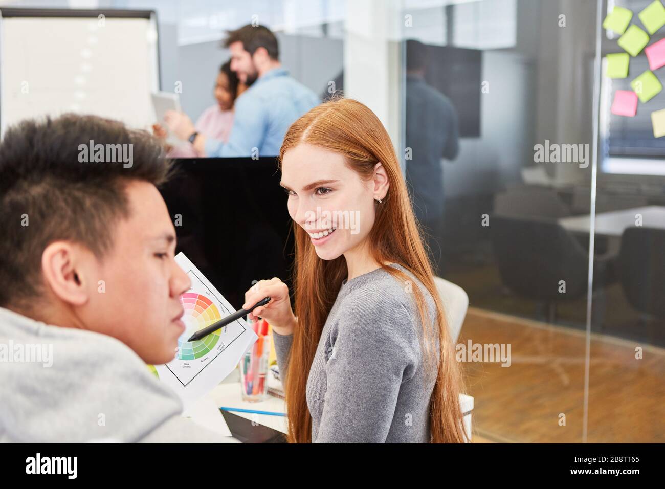 Jeune femme en tant que graphiste en design couleur avec un collègue de l'agence de design Banque D'Images