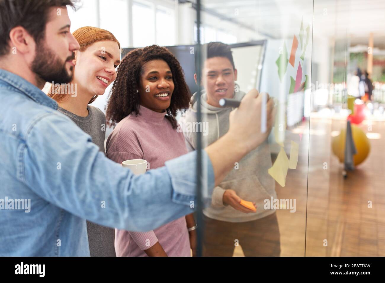 Brainstorming créatif de l'équipe de démarrage avec des notes adhésives sur le mur de verre Banque D'Images