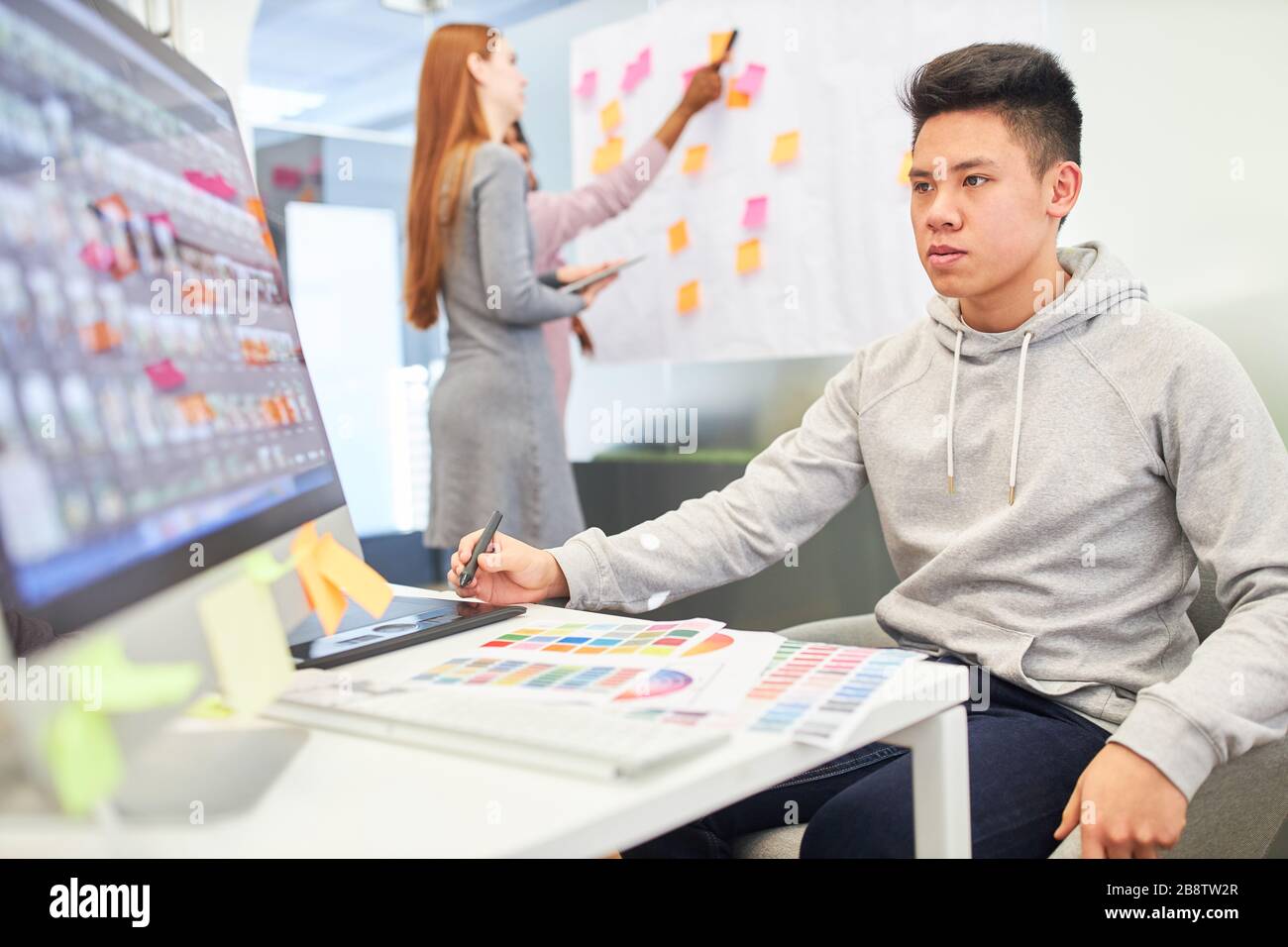 Asian man comme programmeur et développeur Web sur le PC d'une agence Internet Banque D'Images