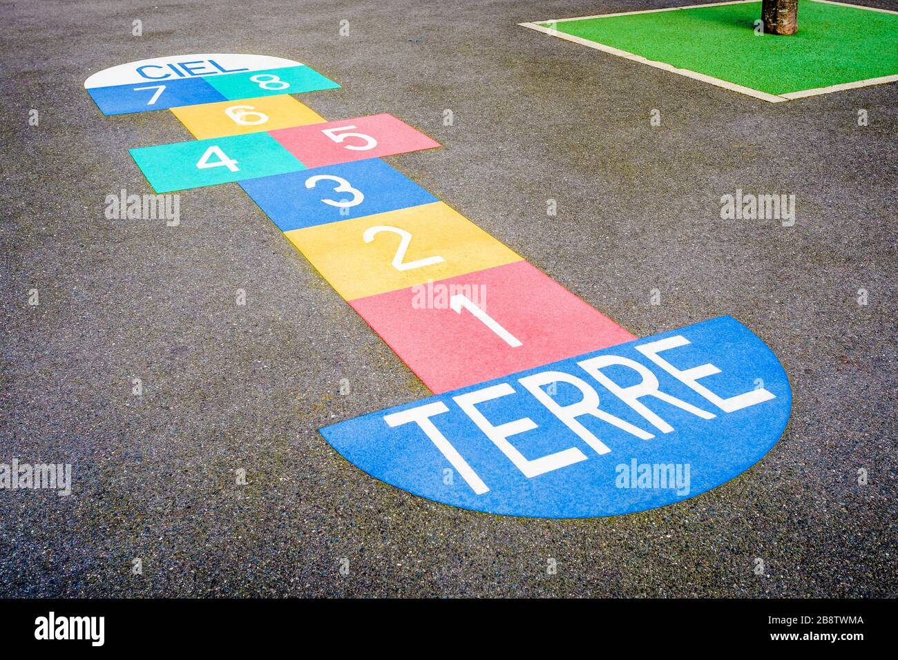 Un hopscotch multicolore peint sur le sol asphalté d'une cour scolaire française. Banque D'Images