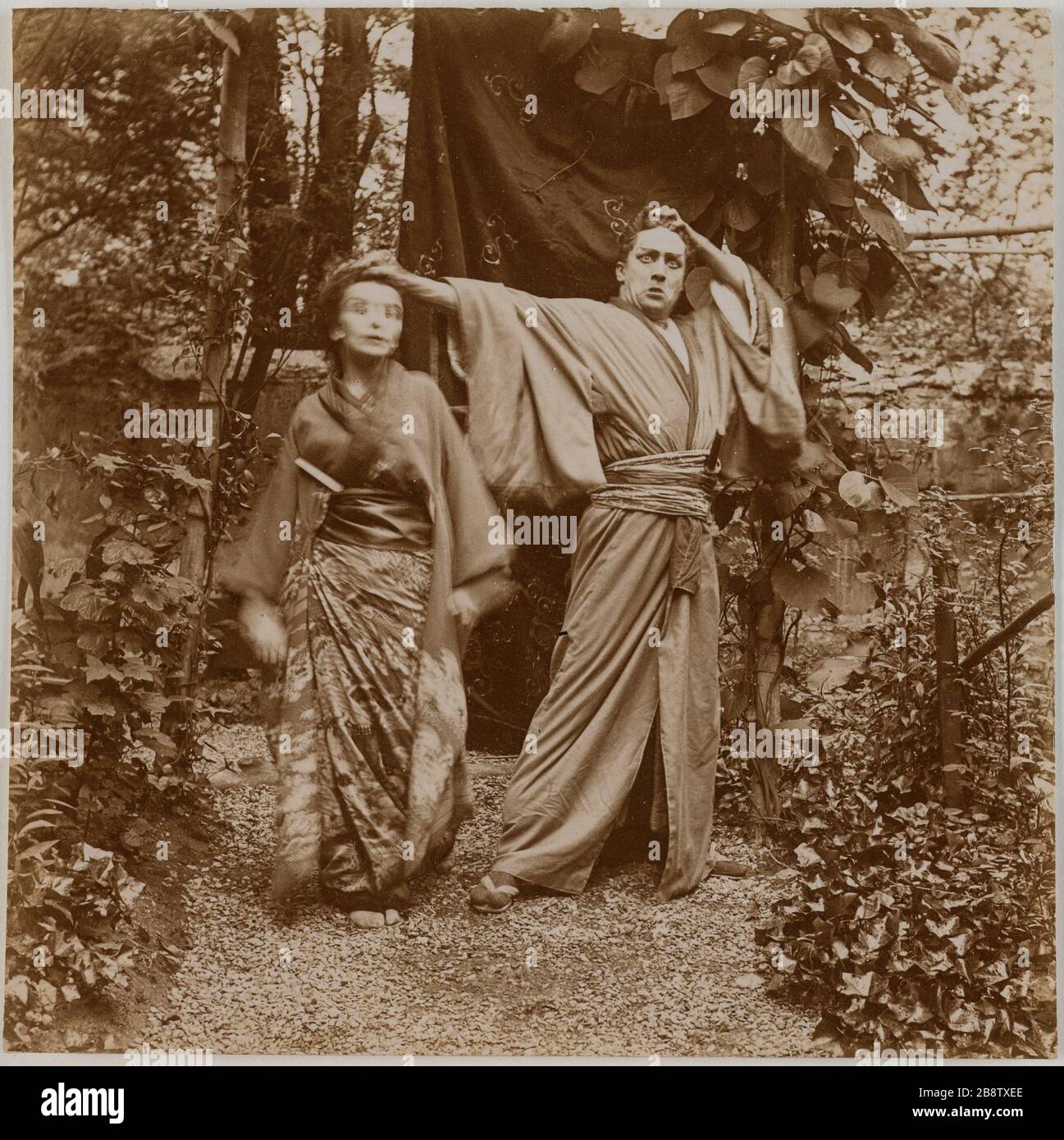 Couple d'acteurs en costume traditionnel japonais jouant le mime dans un jardin. Couple d'acteurs en costumes traditionnels japonais jouant la pantomime dans un jardin. Photographie anonyme, vers 1900. Paris, musée Carnavalet. Banque D'Images