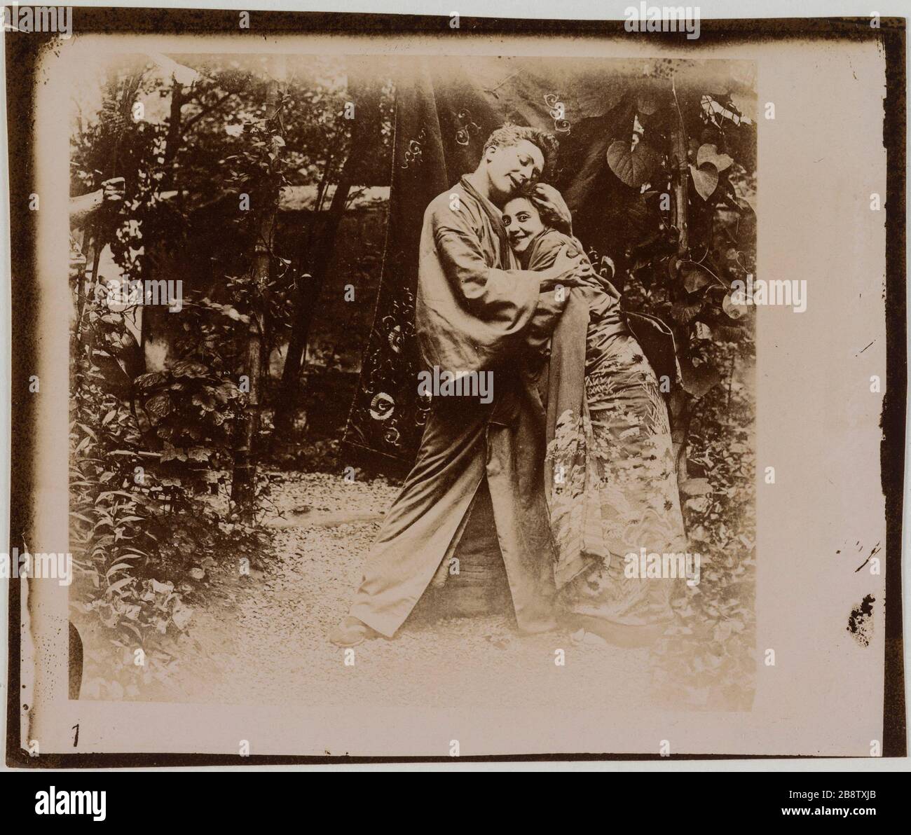 Couple d'acteurs en costume japonais traditionnel embrassant dans un jardin. Couple d'acteurs en costumes traditionnels japonais s'enlaçant dans un jardin. Photographie anonyme, vers 1900. Paris, musée Carnavalet. Banque D'Images