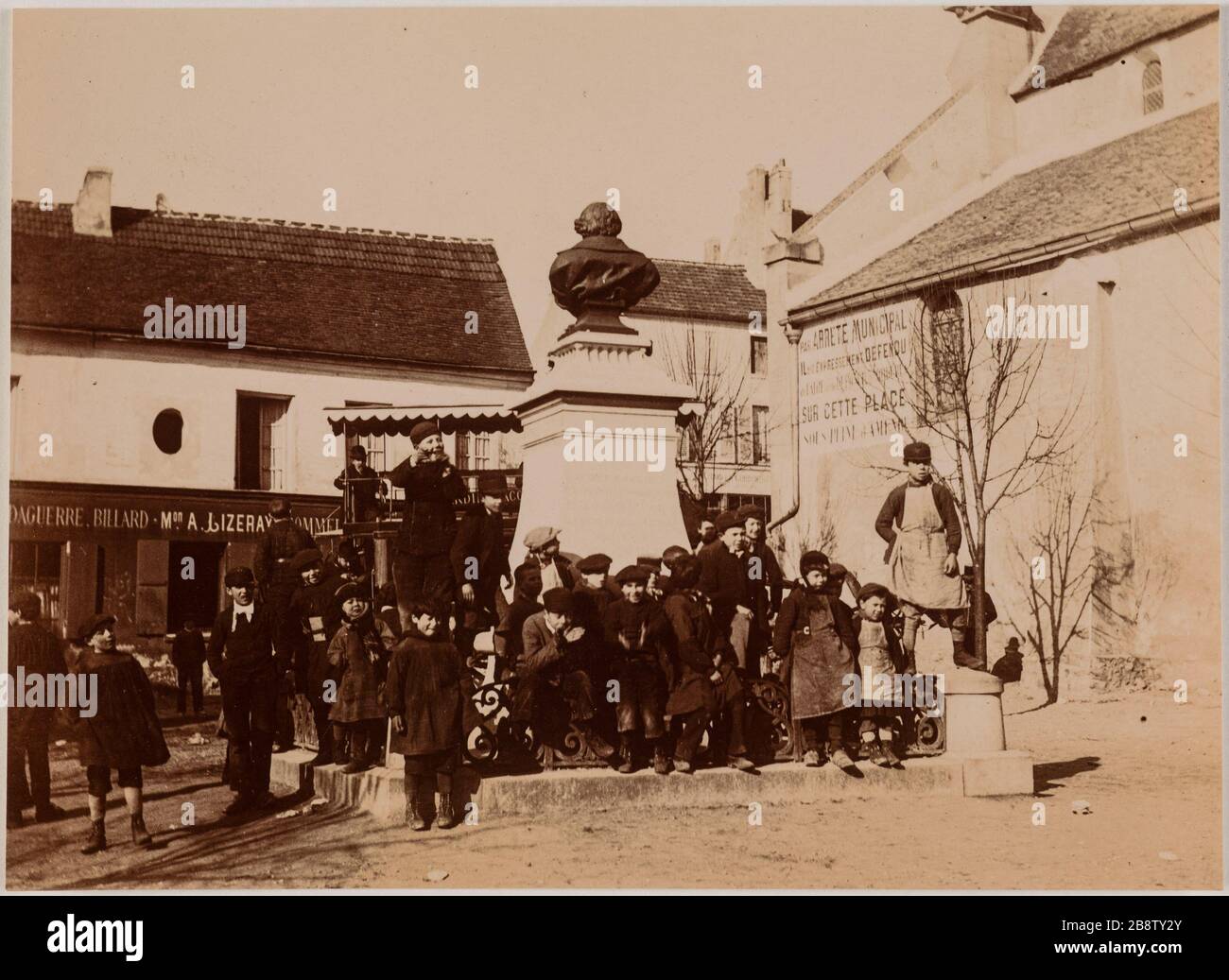 Enfants devant un monument à Louis Jacques Mande Daguerre. Buste en bronze Cormeilles-en-Parisis, place Daguerre (Val-d'Oise) sculpteur Capellaro Charles Romain Joseph 'enfants devant un monument élevé à Jacques Louis Mandé Daguerre. Buste en bronze du sculpteur Capellaro Charles Romain Joseph à Cormeilles-en-Parisis, place Daguerre (Val-d’Oise)'. Photo Club de Paris. Rage au gélatino-chlorure. Paris, musée Carnavalet. Banque D'Images