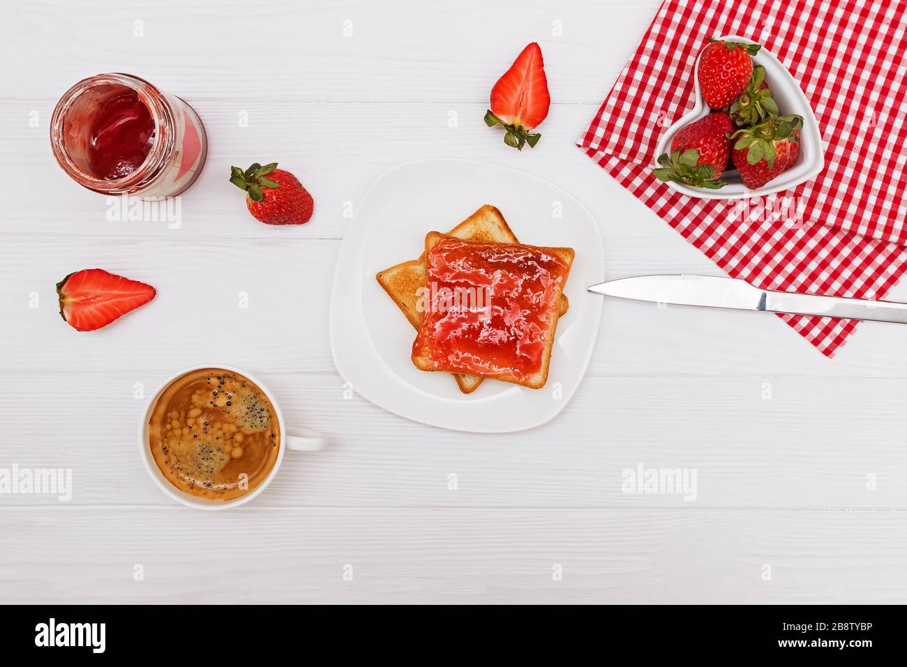 Toast avec confiture de fraises, fraises et café sur la table blanche Banque D'Images