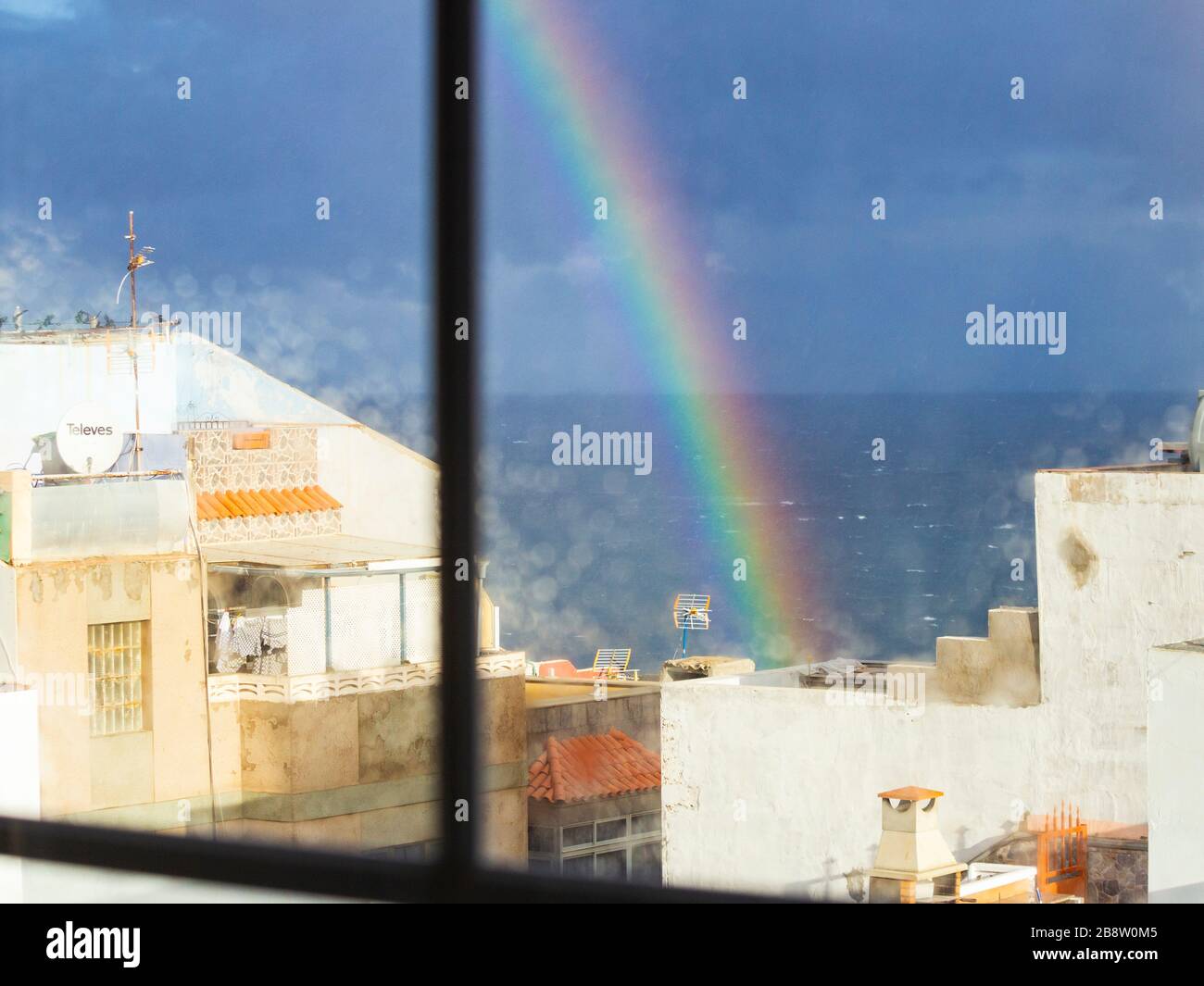 Las Palmas, Grande Canarie, îles Canaries, Espagne. 23 mars 2020. Vue de l'arc-en-ciel sur l'océan Atlantique depuis la fenêtre de l'appartement à Las Palmas, la capitale de Gran Canaria, alors que l'Espagne termine sa première semaine d'un verrouillage strictement appliqué, Le Premier ministre espagnol a annoncé dimanche que l'état d'urgence du dispositif de verrouillage/de quarantaine de Coronavirus serait prolongé jusqu'au 11 avril au moins. En dehors de l'Italie, l'Espagne a le taux d'infection/décès le plus élevé de Covid-19 en Europe. Crédit: Alan Dawson/Alay Live News Banque D'Images