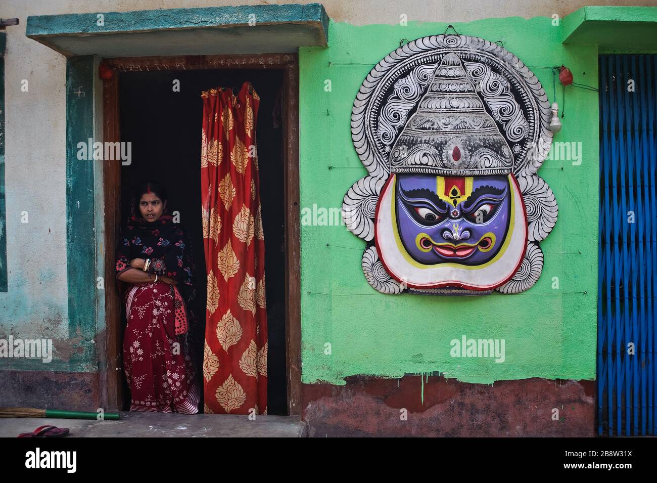 Grand masque représentant une danseuse Kathakali à l'extérieur de la maison d'un artisan faisant et vendant des masques de danse Chhau ( Inde) Banque D'Images