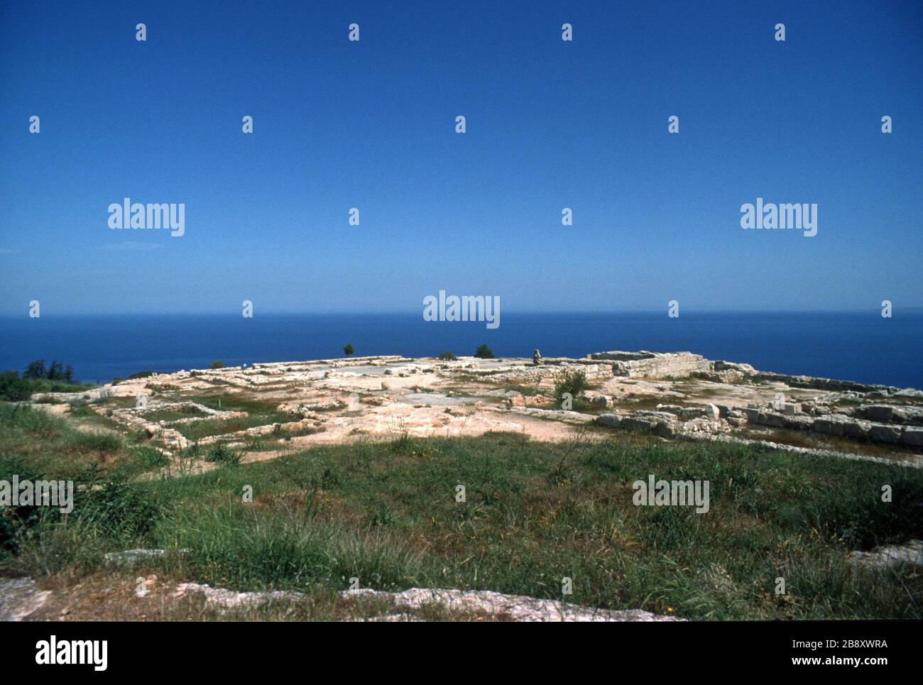 Vestiges du spectaculaire palais de Vouni, au sommet d'une falaise, dans le nord de Chypre. Construit autour de 500 av. J.-C. alors que la région était sous contrôle persan, il a été ensuite repris par les Grecs. Vers 400 av. J.-C., le site a été récupéré par les Perses après la destruction du palais dans un incendie. Un ciel bleu et la mer Méditerranée profonde et bleue en arrière-plan. Banque D'Images