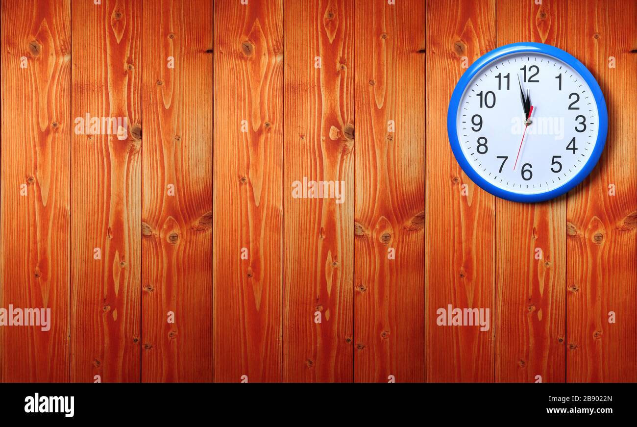 Horloge murale bleue avec minuit nouvel an sur fond en bois Banque D'Images