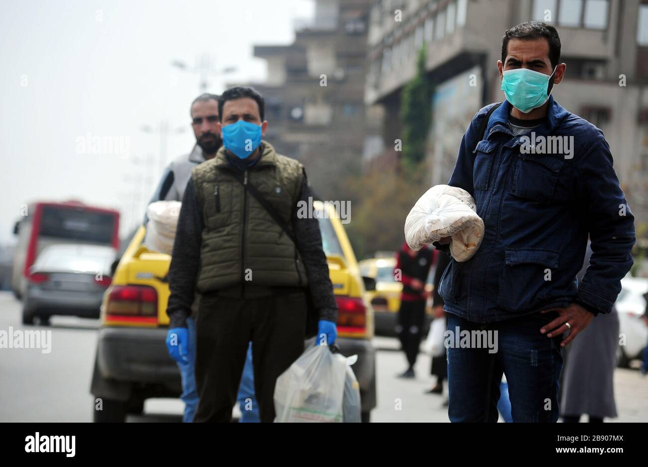 Damas, Syrie. 23 mars 2020. Les personnes portant des masques se trouvent dans une rue de Damas, en Syrie, le 23 mars 2020. Dimanche, le Ministère syrien de la santé a confirmé le premier cas nouveau de coronavirus dans le pays, a déclaré State TV. Crédit: Ammar Safarjalani/Xinhua/Alay Live News Banque D'Images
