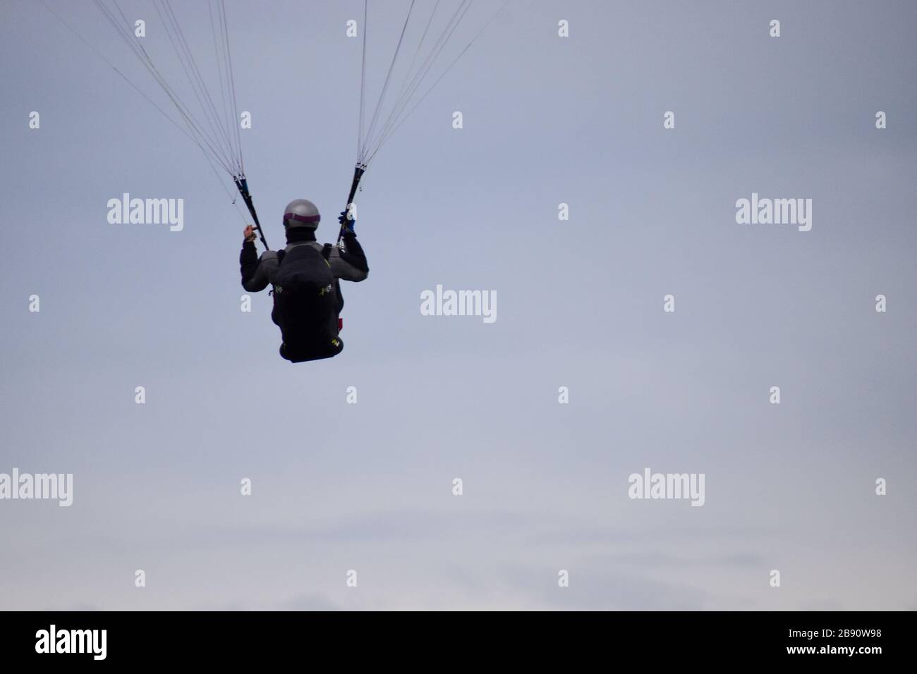 Concept de succès. Un homme parapente dans un ciel clair Banque D'Images