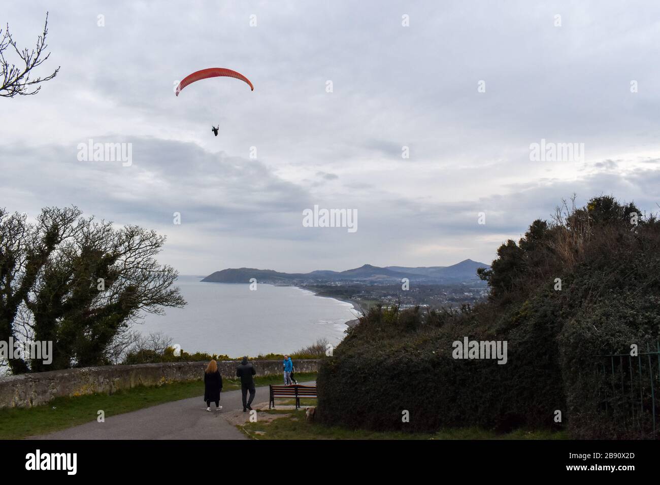 Concept de succès. Un homme parapente dans un ciel clair sur la côte de l'Irlande Banque D'Images