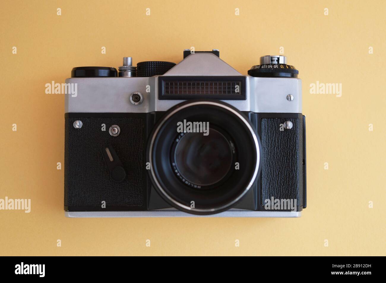 Vue du dessus sur un appareil photo à film vintage sur fond jaune. Cadre noir en métal argenté et en plastique avec objectif. Banque D'Images