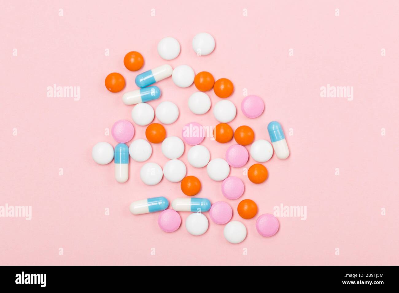 Assortiment de pilules, comprimés et capsules de médecine pharmaceutique sur fond rose. Espace libre. Gros plan sur le concept de santé Banque D'Images