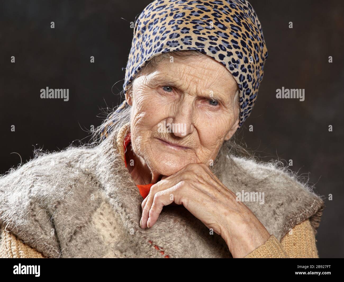 Portrait en gros plan de la vieille femme avec un aspect réfléchi sur un arrière-plan sombre.Les personnes de cet âge sont les plus vulnérables durant les épidémies. Banque D'Images
