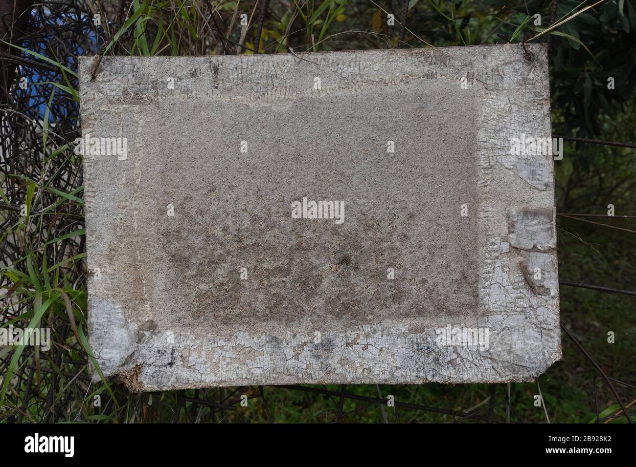 Panneau en bois blanc sur clôture rouillée. Elément de conception d'arrière-plan avec espace de copie. Banque D'Images