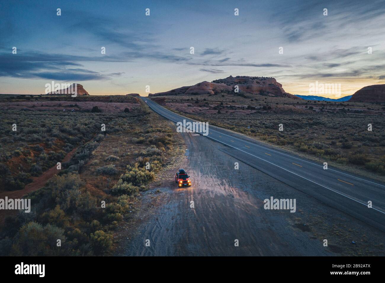 La route de l'Utah est isolée le soir avec une voiture tirée Banque D'Images