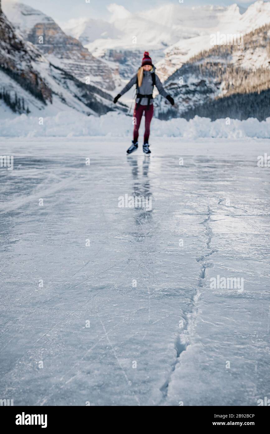 Jeune femme patinant sur le lac gelé vers la glace Banque D'Images