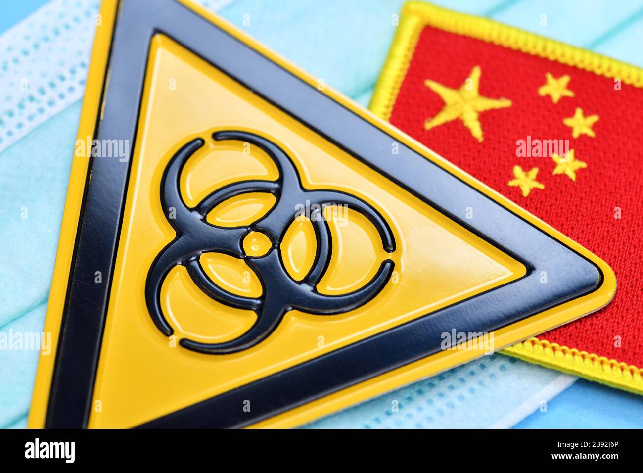 Biologie signe de danger et drapeau de la Chine sur un masque, photo symbolique Coronavirus, Biogefährdungsschild und Fahne von China auf einem Mundschutz, Symbolfoto Banque D'Images