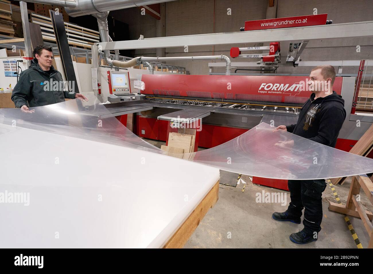 Urmitz, Allemagne. 23 mars 2020. Les employés de l'entreprise action Light, qui gère normalement la technologie des événements et la construction des stands d'exposition, coupent des feuilles de Plexiglas pour les murs de protection des caisses de supermarché et des opérations chirurgicales des médecins. Les caissiers dans les supermarchés en particulier peuvent se infecter et ensuite leurs clients avec la maladie pulmonaire corona. (Vers dpa 'Company passe à la production de cloisons pour les caissiers') crédit: Thomas Frey/dpa/Alay Live News Banque D'Images