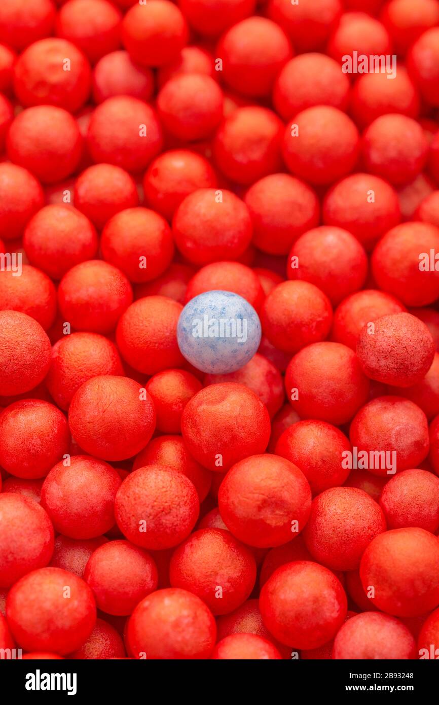 Petites boules de polystyrène de couleur rouge et bleu. Conceptuel pour l'auto-isolation de Covid-19, porteur de maladie, personne infectée, isolée, perdue dans la foule. Banque D'Images