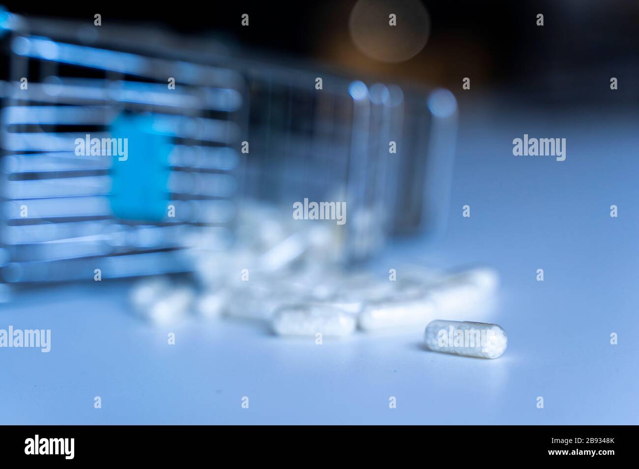 pile de pilules médicinales blanches déversées sur une table à partir d'un panier miniature Banque D'Images