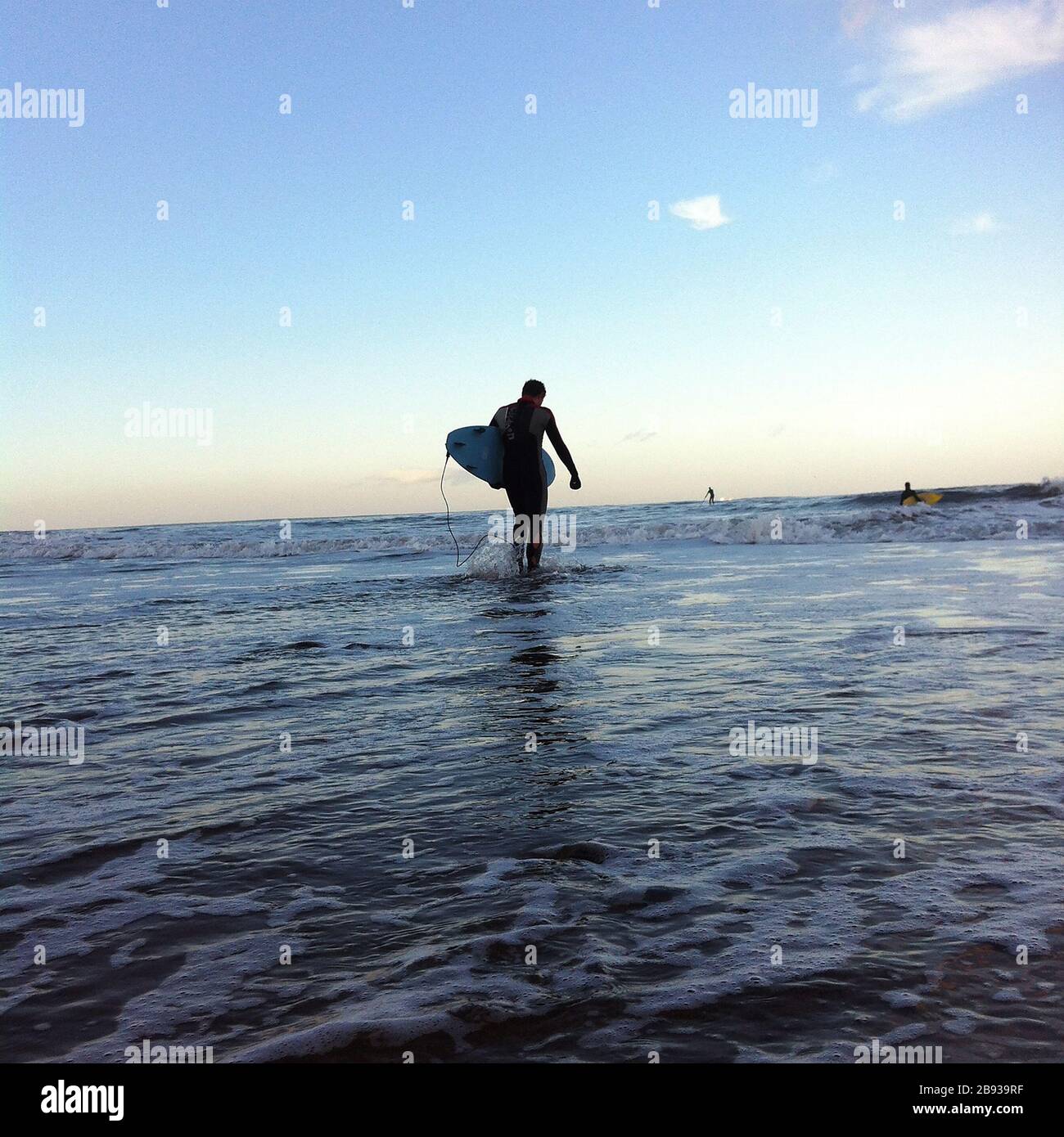 Un surfeur entre dans la mer près de Staithes, dans le North Yorkshire, au Royaume-Uni. Banque D'Images