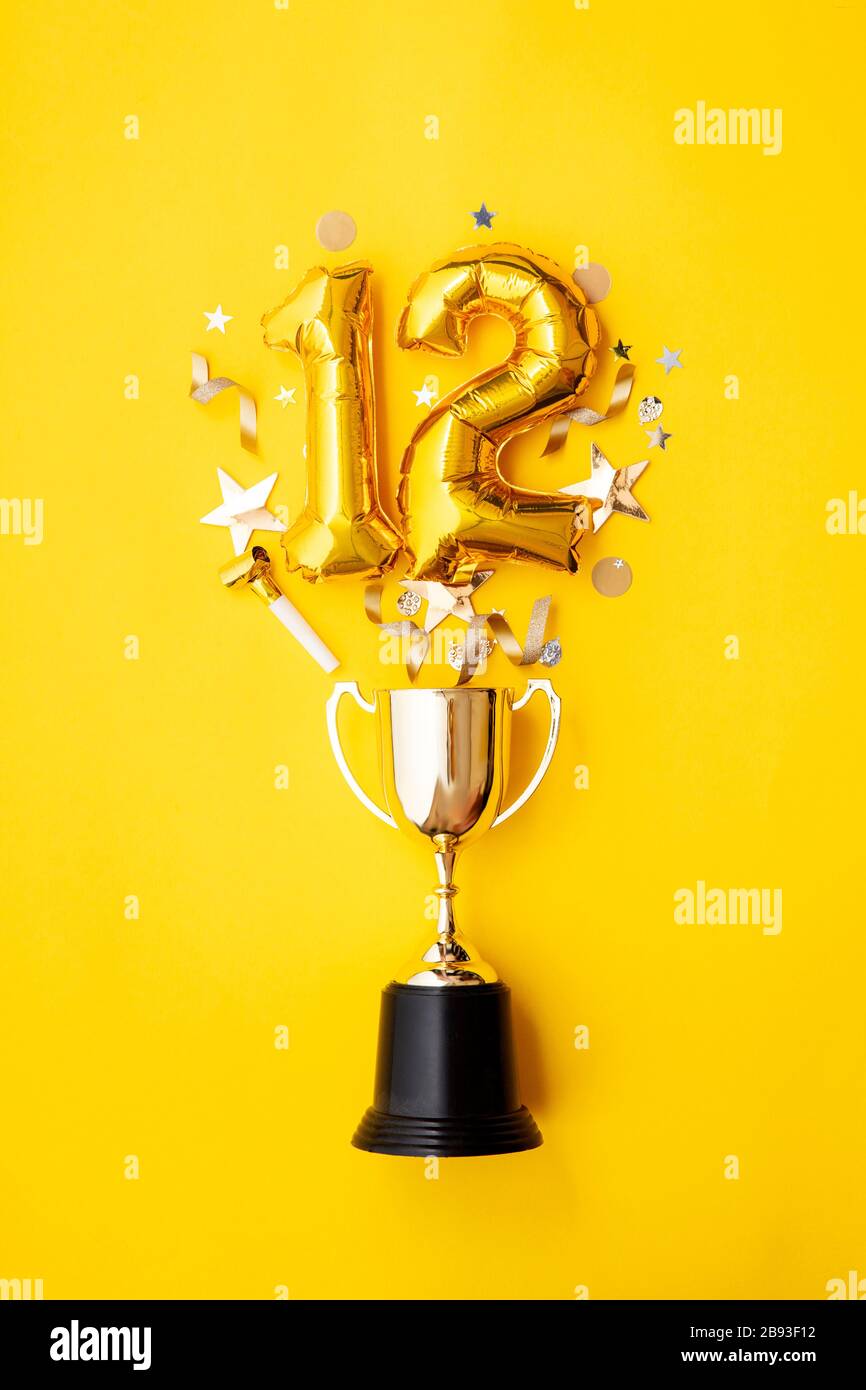 Le ballon numéro 12 de célébration de l'anniversaire de l'or explose à partir d'un trophée gagnant Banque D'Images