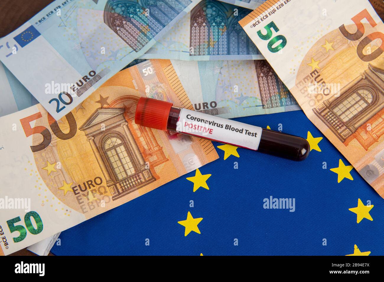 Billets en euros avec drapeau de l'UE et coronavirus sang test covid-19 crise économique Banque D'Images