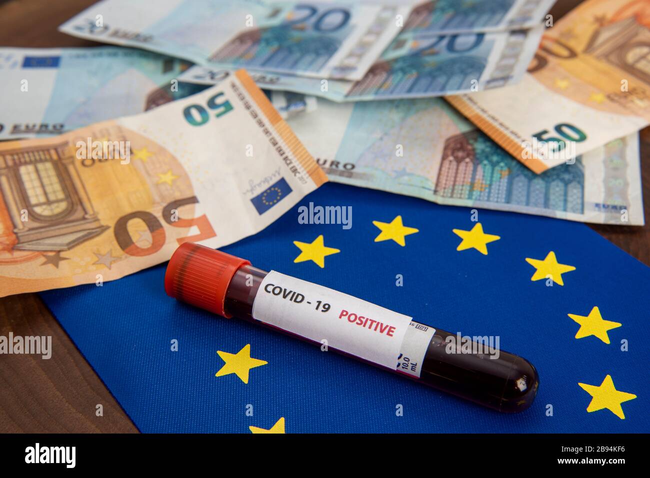 Billets en euros avec drapeau de l'UE et coronavirus sang test covid-19 crise économique Banque D'Images