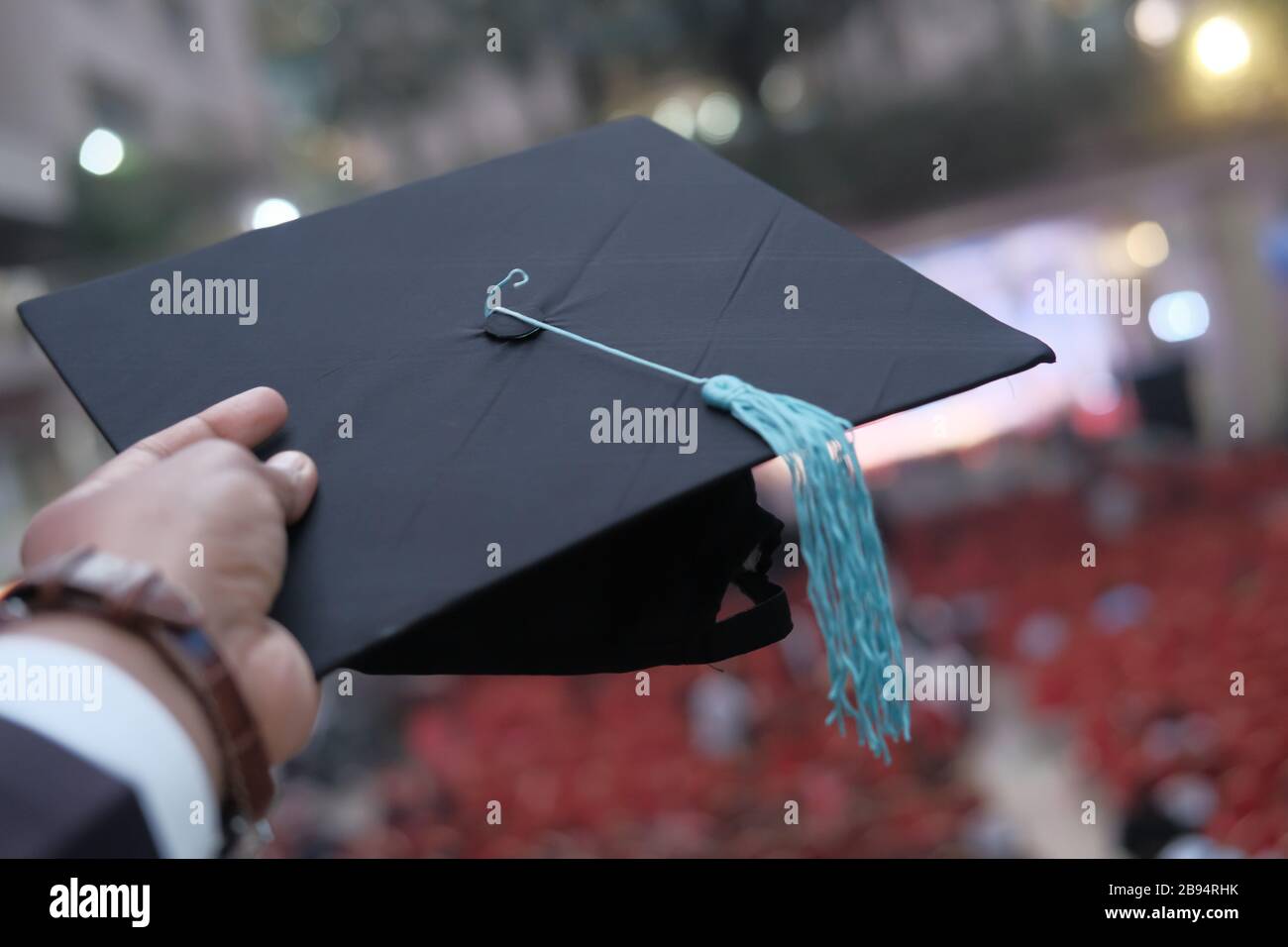 Homme main tenant chapeau de graduation extérieur. Banque D'Images