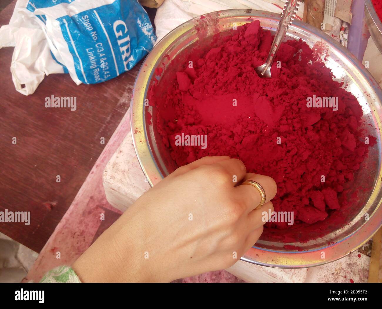 Belles mains dans la poudre de couleur de Hali rouge dans un bol - Hali est un ancien festival hindou populaire, originaire du sous-continent indien Banque D'Images