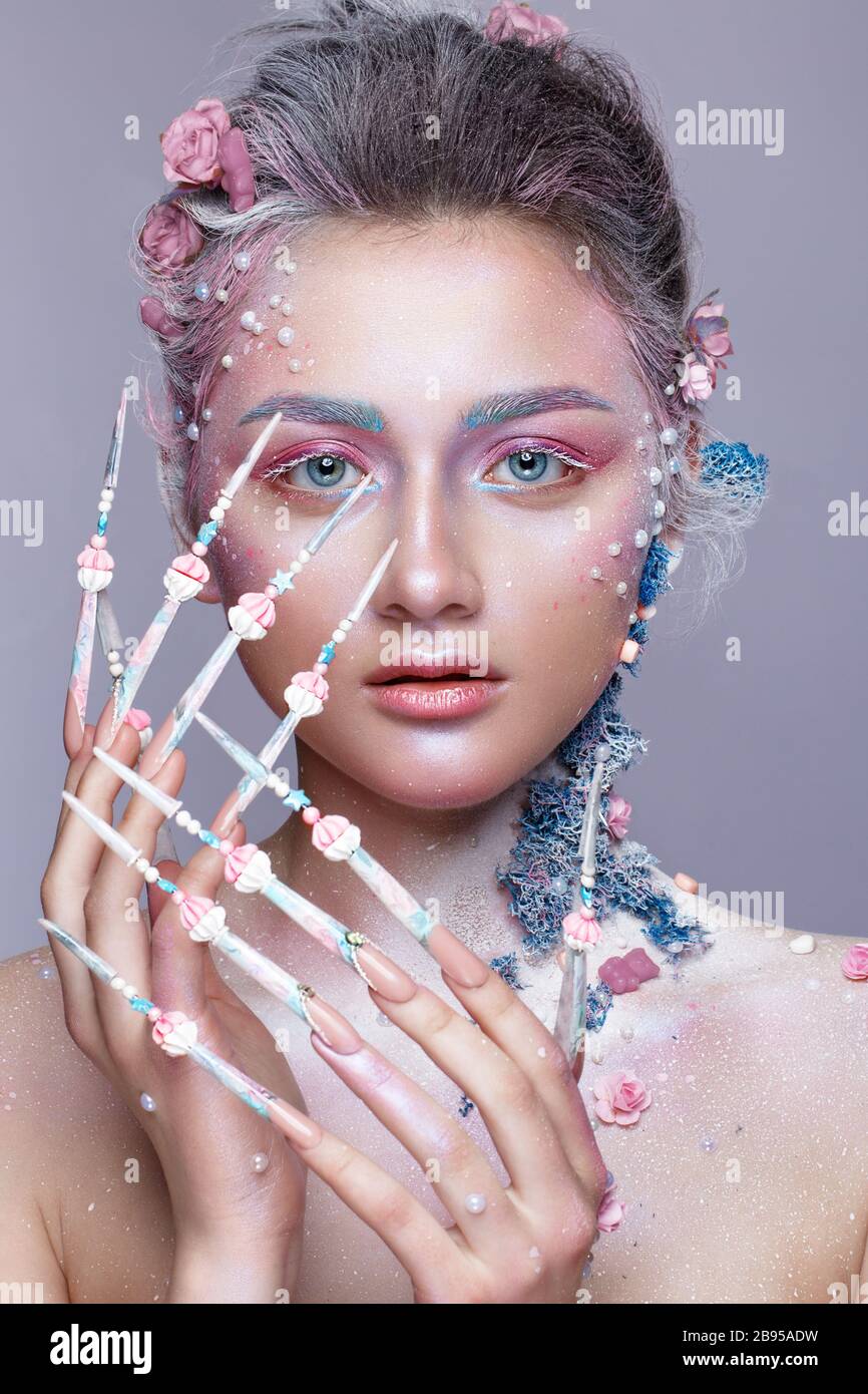 Belle fille à l'image d'une jolie fée avec un art de la taille et avec de longs ongles design. Manucure créative. Banque D'Images